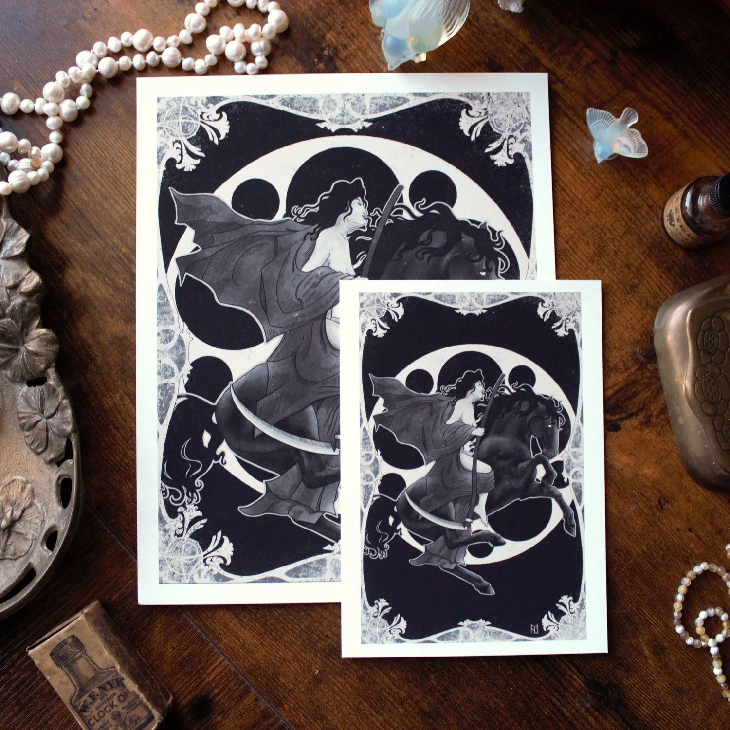 Two black and white illustrations of Lady Death riding a black horse on a wooden surface with decorative items.