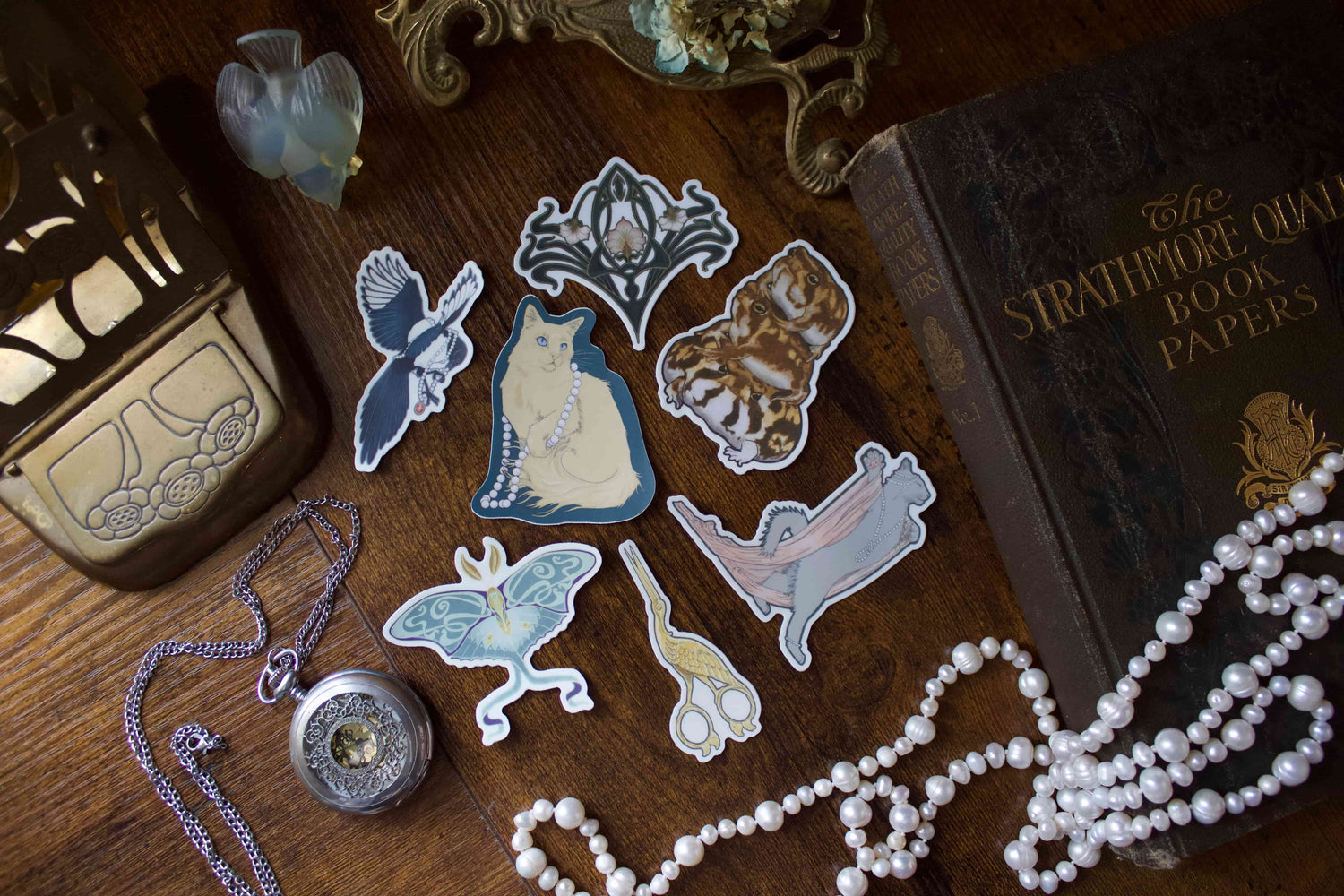 Decorative stickers on a wooden surface with a book and jewelry